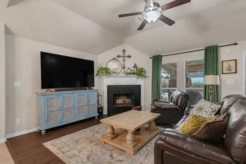 a living room with furniture a flat screen tv and a fireplace