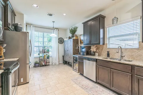 a kitchen with stainless steel appliances granite countertop a refrigerator and a sink