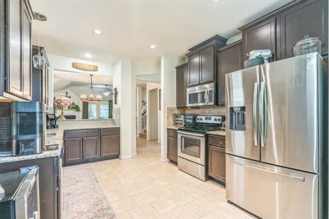 a kitchen with granite countertop stainless steel appliances and refrigerator