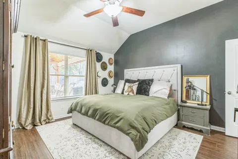 a bedroom with a large bed and a chandelier