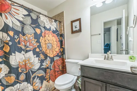 a bathroom with a sink and mirror with toilet