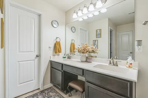 a bathroom with a double vanity sink and a mirror