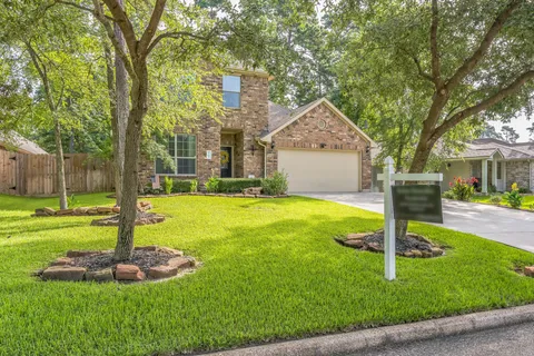 a front view of a house with a yard and tree