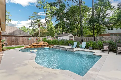 a view of a swimming pool with a patio and a garden
