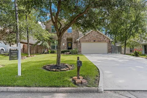 a front view of a house with a yard and tree