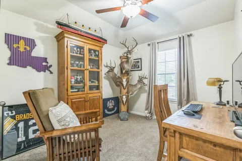 a view of a workspace with furniture and a window