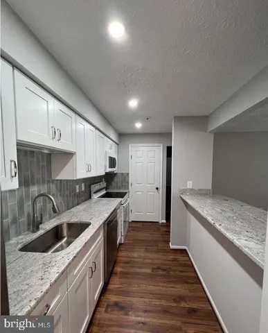 a kitchen with a sink stove top oven and cabinets