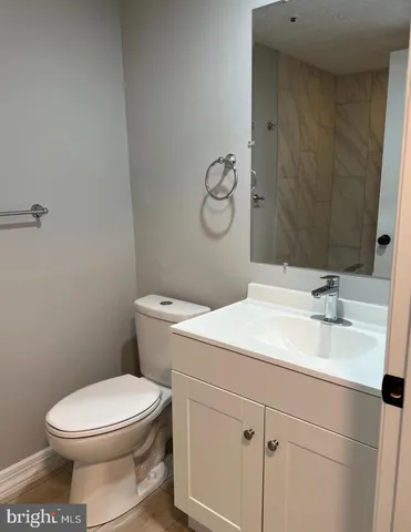 a bathroom with a sink vanity mirror and toilet
