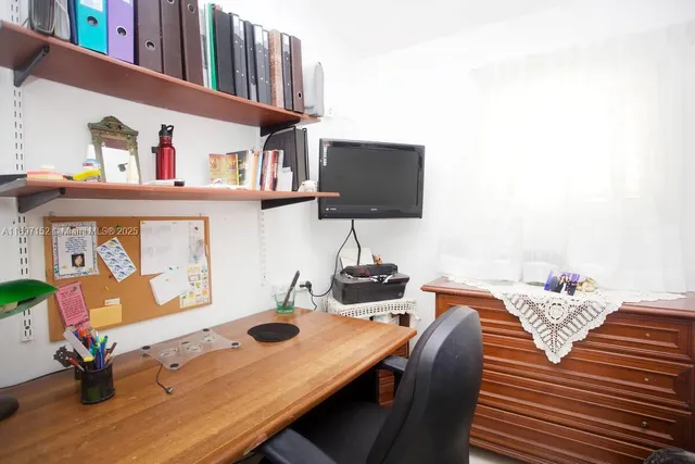 a bedroom with a bed and a lamp on dresser