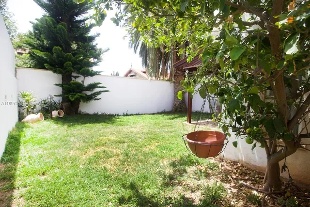 a backyard of a house with table and chairs