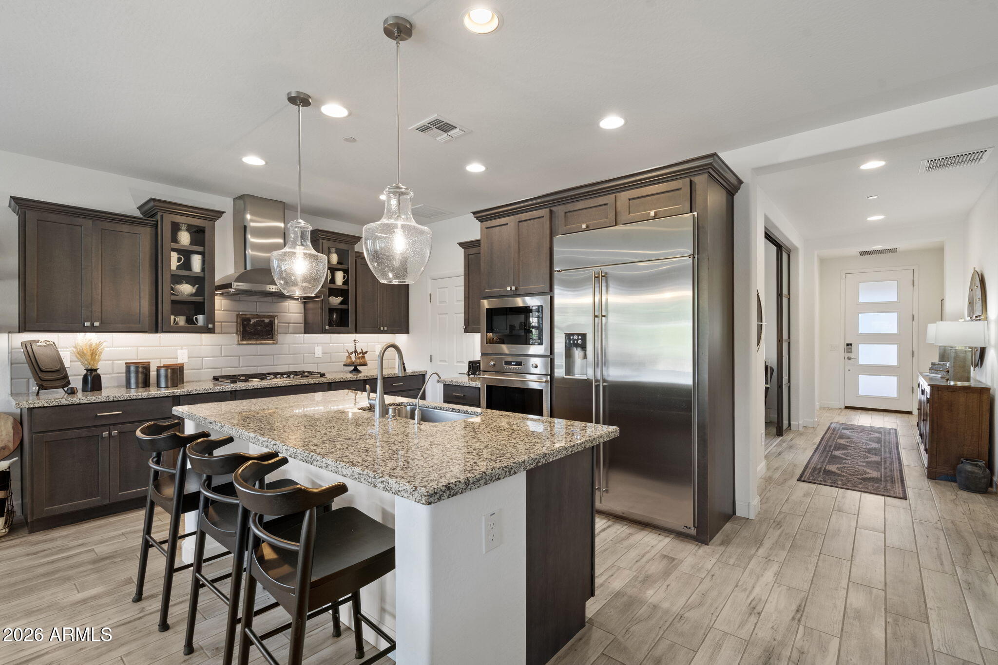17521 East Silver Sage Lane Rio Verde, AZ 85263 - Photo 8 of 27 a kitchen with stainless steel appliances granite countertop table chairs refrigerator and wooden floor
