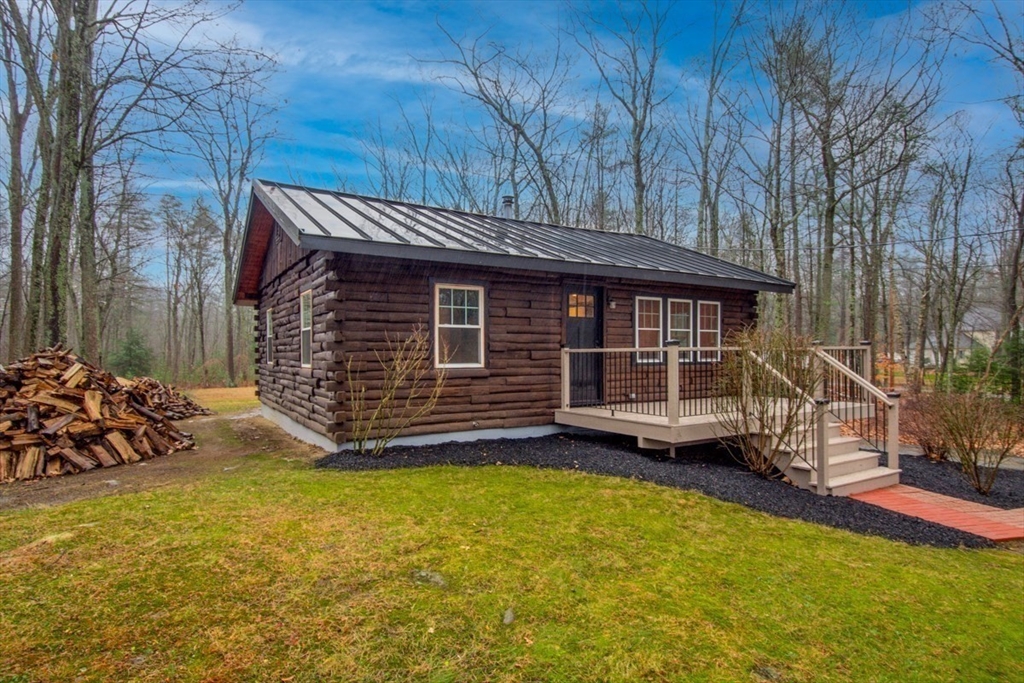 a view of a house with a yard and wooden fence