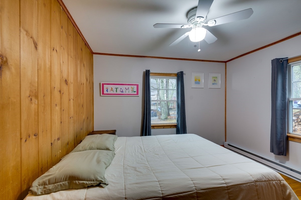 100 Dunn Road Ashburnham, MA 01430 - Photo 24 of 31 a bedroom with a large bed chandelier and a window