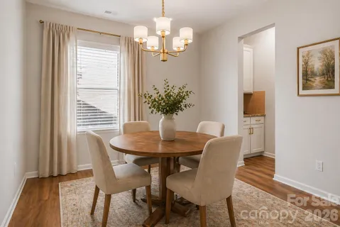 a kitchen with granite countertop a refrigerator a stove a kitchen island with wooden floor and cabinets