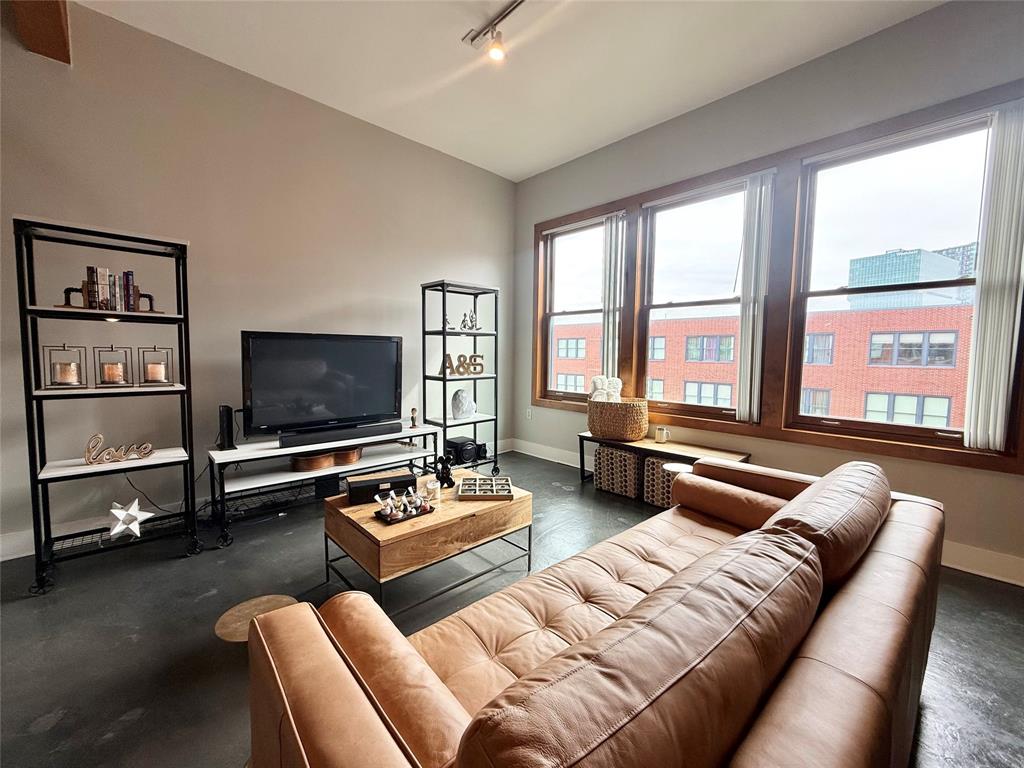 2502 Live Oak Street, Unit 302 Dallas, TX 75204 - Photo 1 of 1 a living room with furniture a flat screen tv and a large window