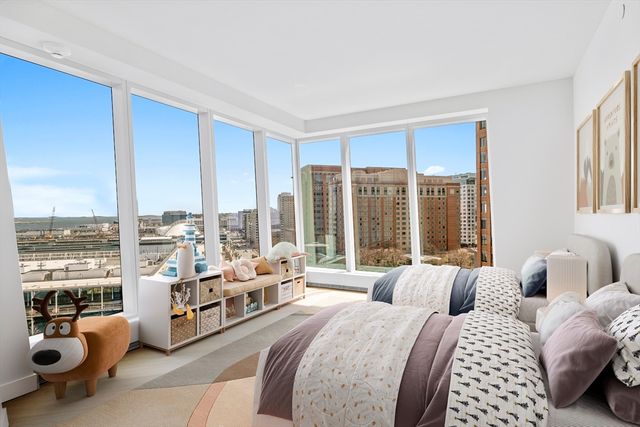 a spacious bedroom with a bed and large windows