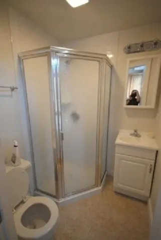 a bathroom with a shower a toilet and a sink