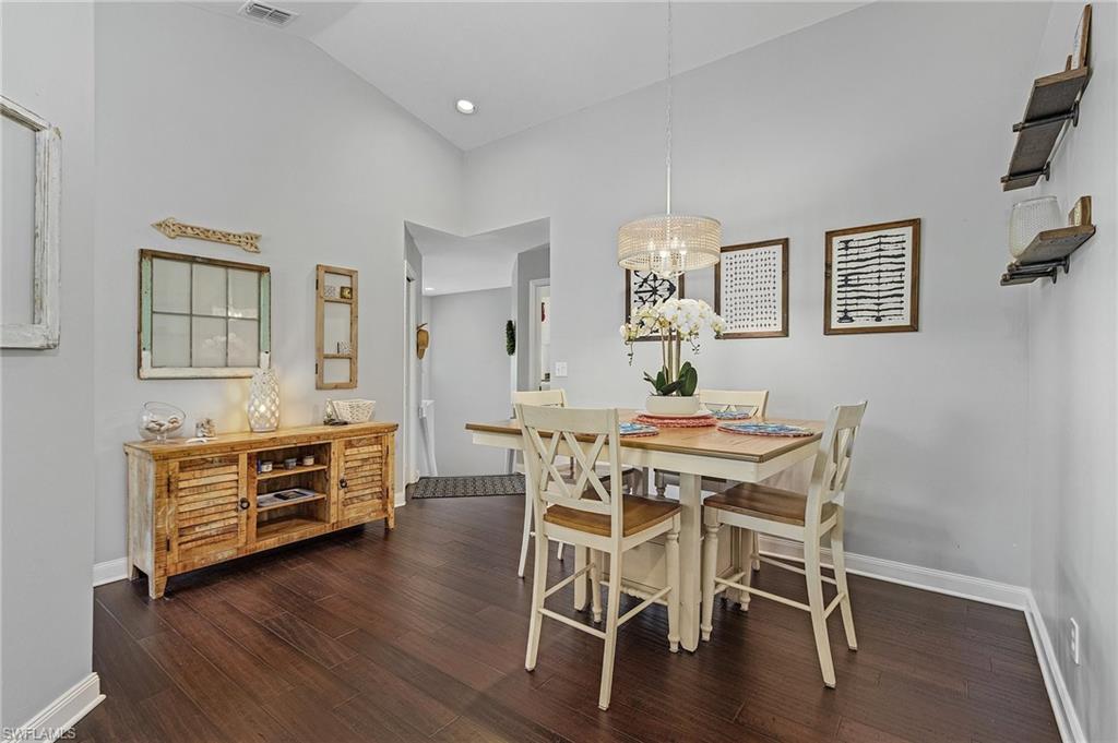 3785 Fieldstone Boulevard, Unit 208 Naples, FL 34109 - Photo 11 of 26 Dining space featuring wood flooring, and a notable chandelier
