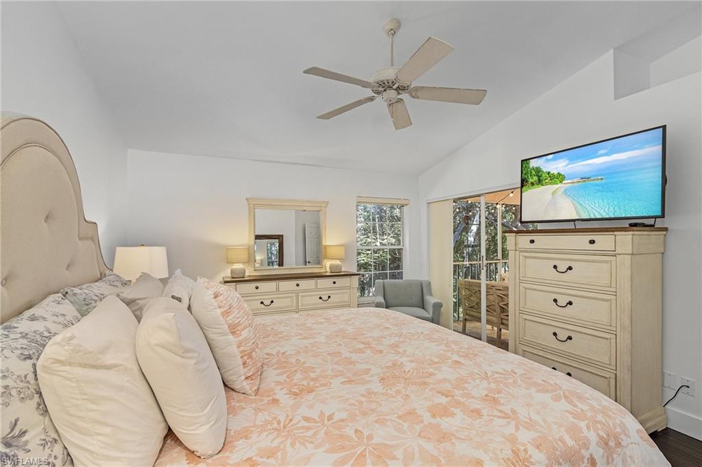 3785 Fieldstone Boulevard, Unit 208 Naples, FL 34109 - Photo 14 of 26 Bedroom featuring lofted ceiling, ceiling fan, wood floors, and access to exterior