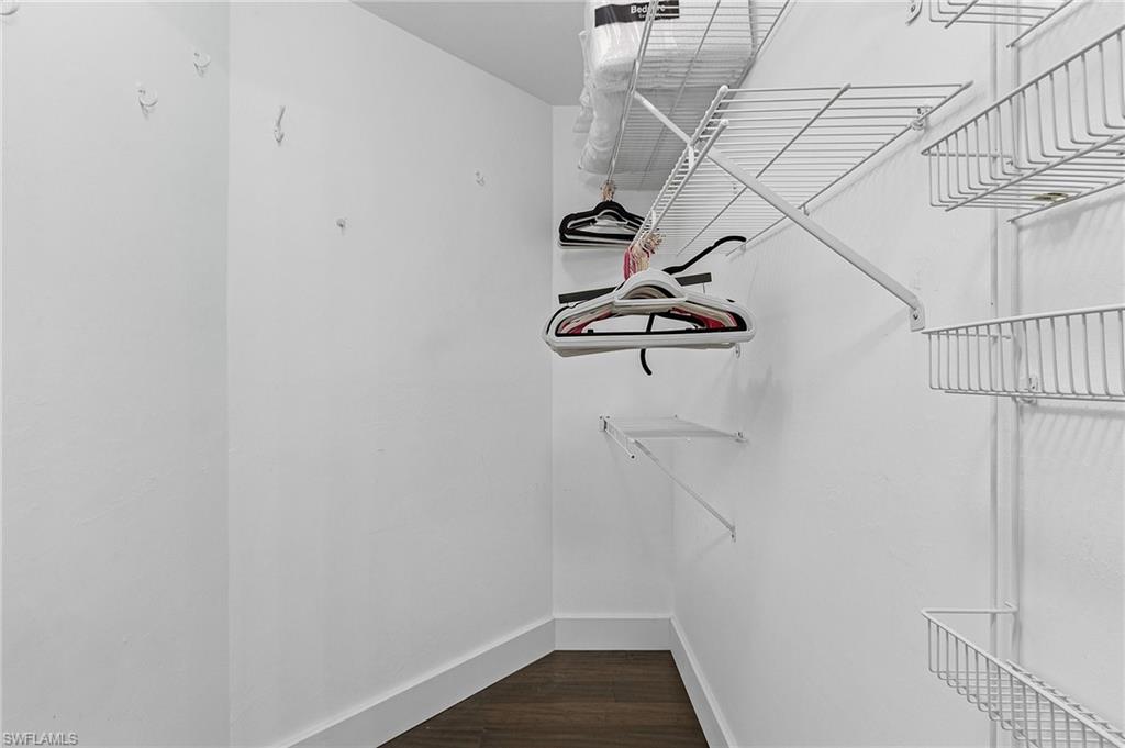 3785 Fieldstone Boulevard, Unit 208 Naples, FL 34109 - Photo 16 of 26 Master Walk in closet featuring dark wood floors