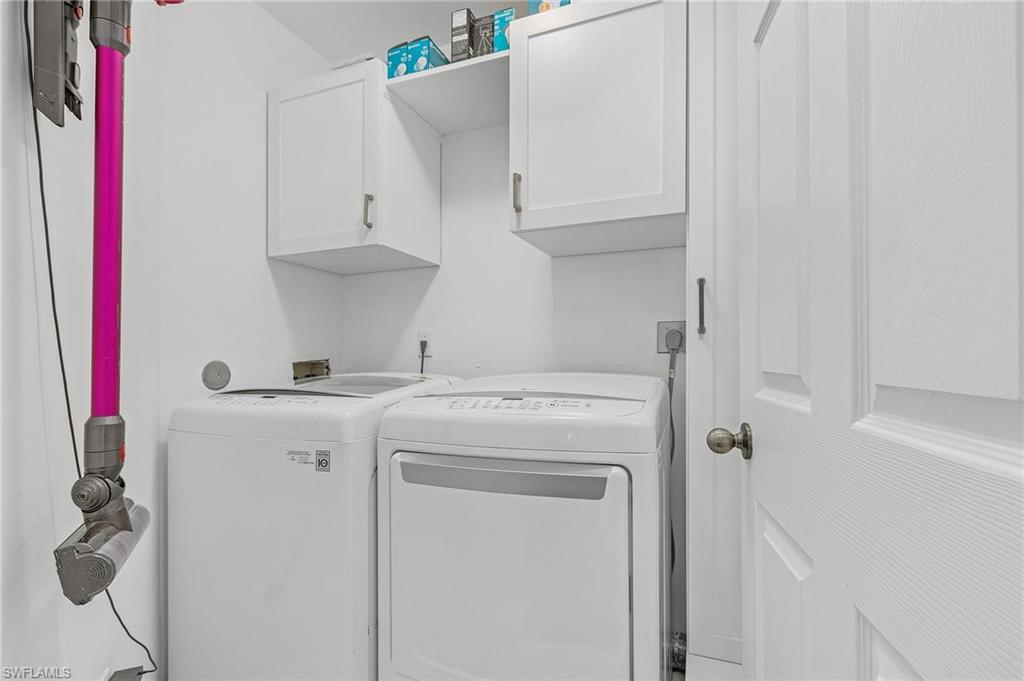 3785 Fieldstone Boulevard, Unit 208 Naples, FL 34109 - Photo 19 of 26 Clothes washing area with cabinet space and washer and clothes dryer