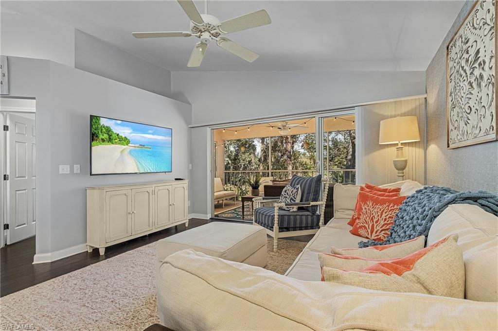 3785 Fieldstone Boulevard, Unit 208 Naples, FL 34109 - Photo 2 of 26 Living area featuring ceiling fan, vaulted ceiling, and wood floors