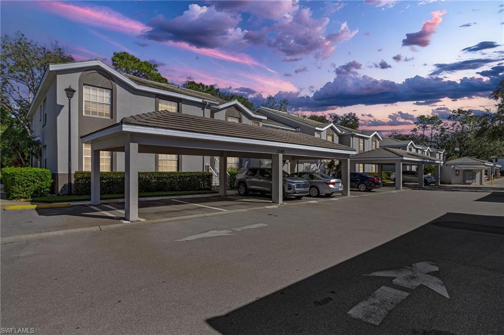 3785 Fieldstone Boulevard, Unit 208 Naples, FL 34109 - Photo 22 of 26 Property at dusk with covered parking