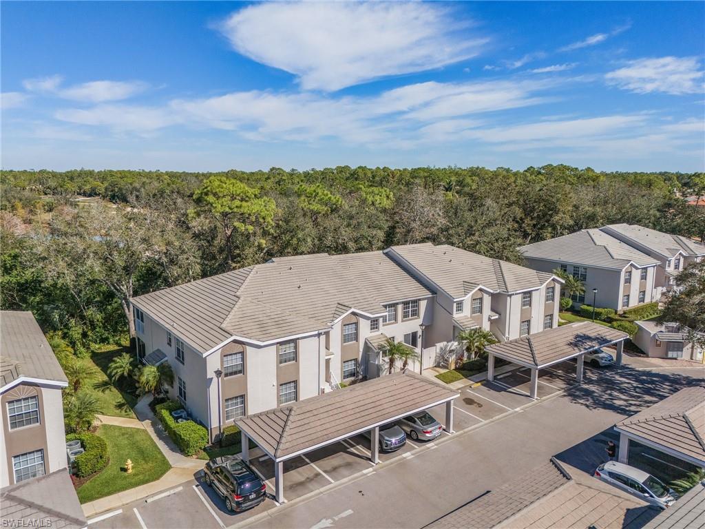 3785 Fieldstone Boulevard, Unit 208 Naples, FL 34109 - Photo 24 of 26 Aerial view featuring a residential view and a wooded view