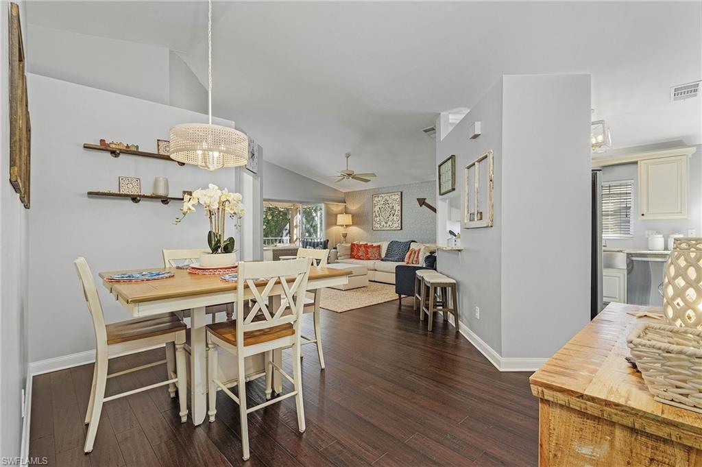 3785 Fieldstone Boulevard, Unit 208 Naples, FL 34109 - Photo 9 of 26 Dining space featuring a wealth of natural light, vaulted ceiling, and wood flooring