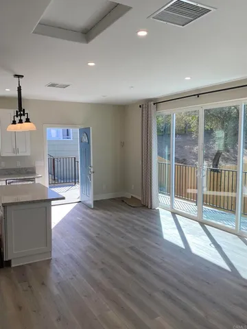 an empty room with wooden floor and outdoor view