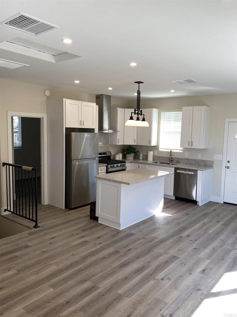 8545 Lemon Avenue, Unit 1 La Mesa, CA 91941 - Photo 6 of 28 a large kitchen with stainless steel appliances granite countertop a stove a refrigerator and a wooden floors