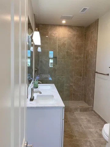 a bathroom with a sink a toilet and shower