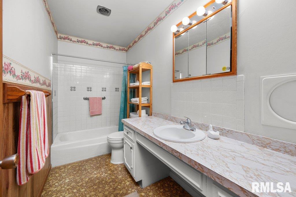 513 12th Avenue Hampton, IL 61256 - Photo 13 of 35 a bathroom with a granite countertop sink a mirror a bathtub and shower