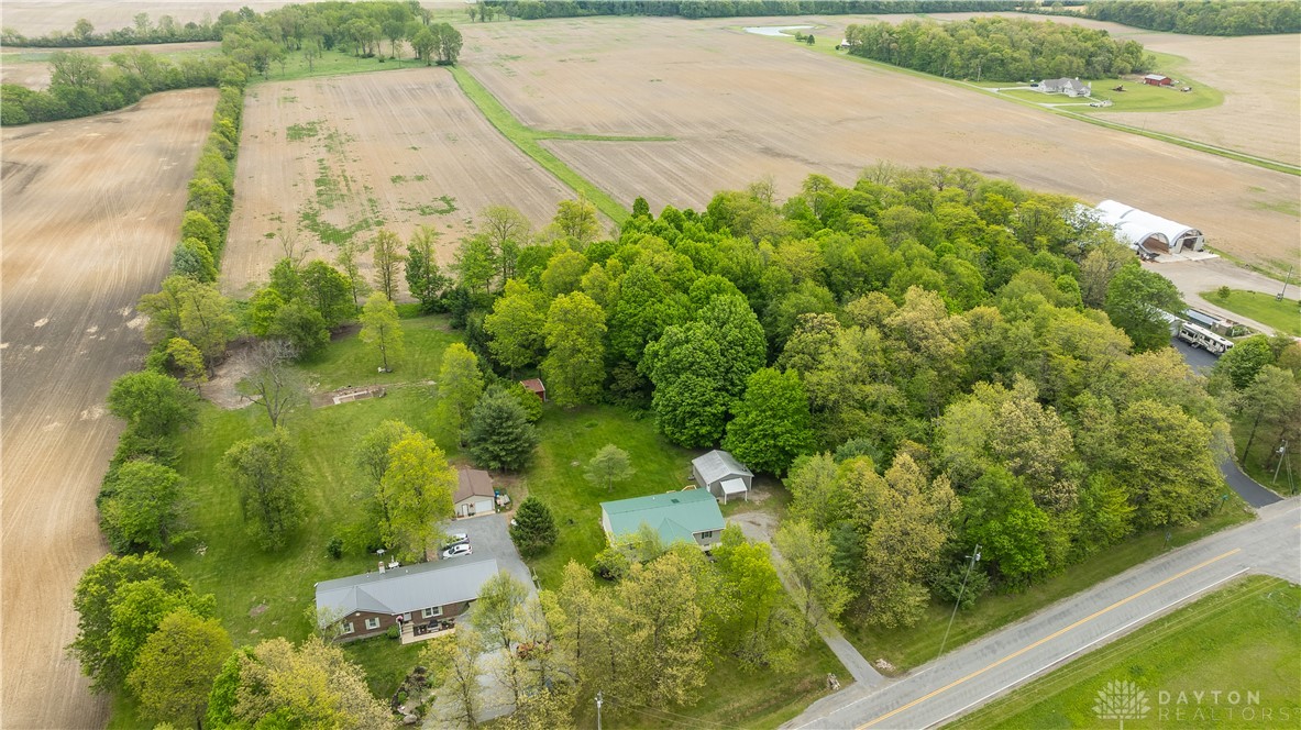1319 Perry Road Cable, OH 43009 - Photo 6 of 44 An aerial view captures the vast land with lush trees and a serene road winding through it.