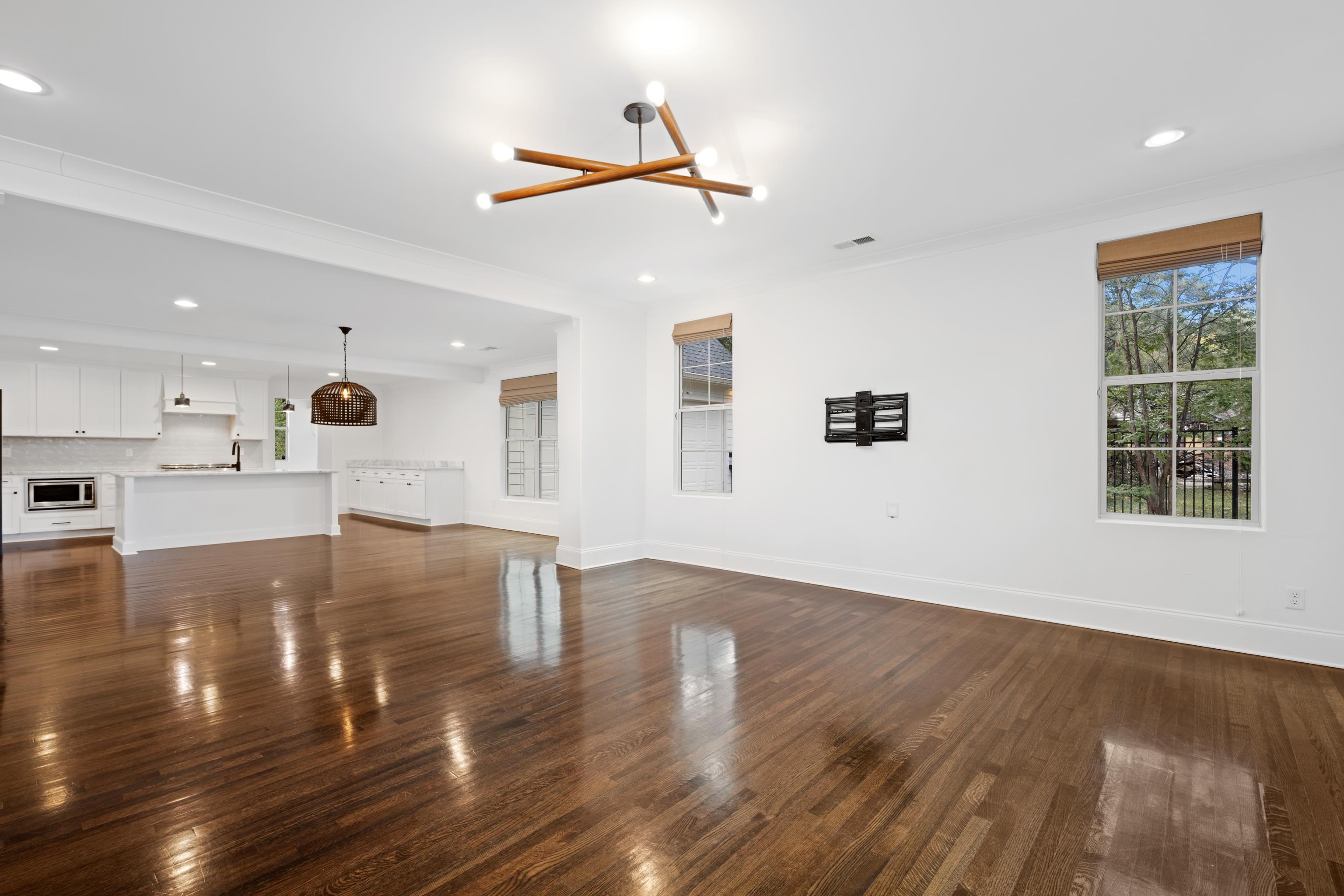 a view of empty room with wooden floor and windows