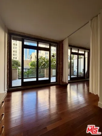 a view of empty room with wooden floor and floor to ceiling window