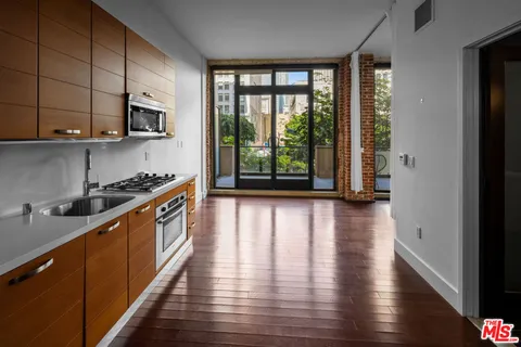 a view of empty room with wooden floor and floor to ceiling window