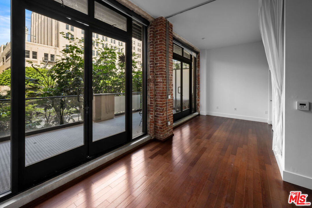 460 South Spring Street, Unit 205 Los Angeles, CA 90013 - Photo 2 of 21 a view of empty room with wooden floor and floor to ceiling window