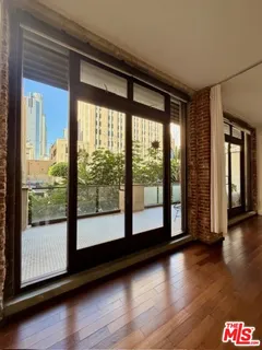 a view of empty room with wooden floor and floor to ceiling window