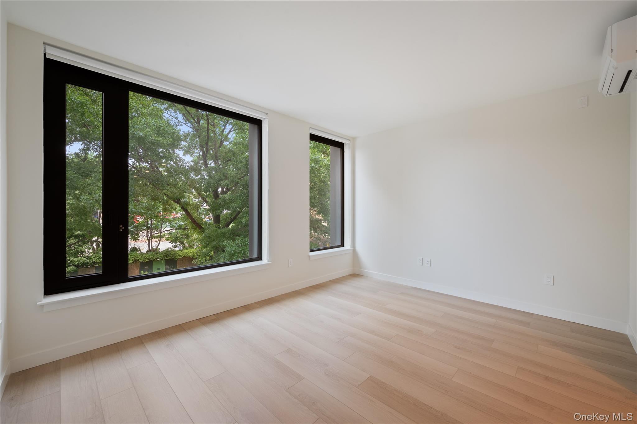 15310-unit #804 15310-unit Avenue Queens, NY 11432 - Photo 3 of 19 an empty room with wooden floor and windows