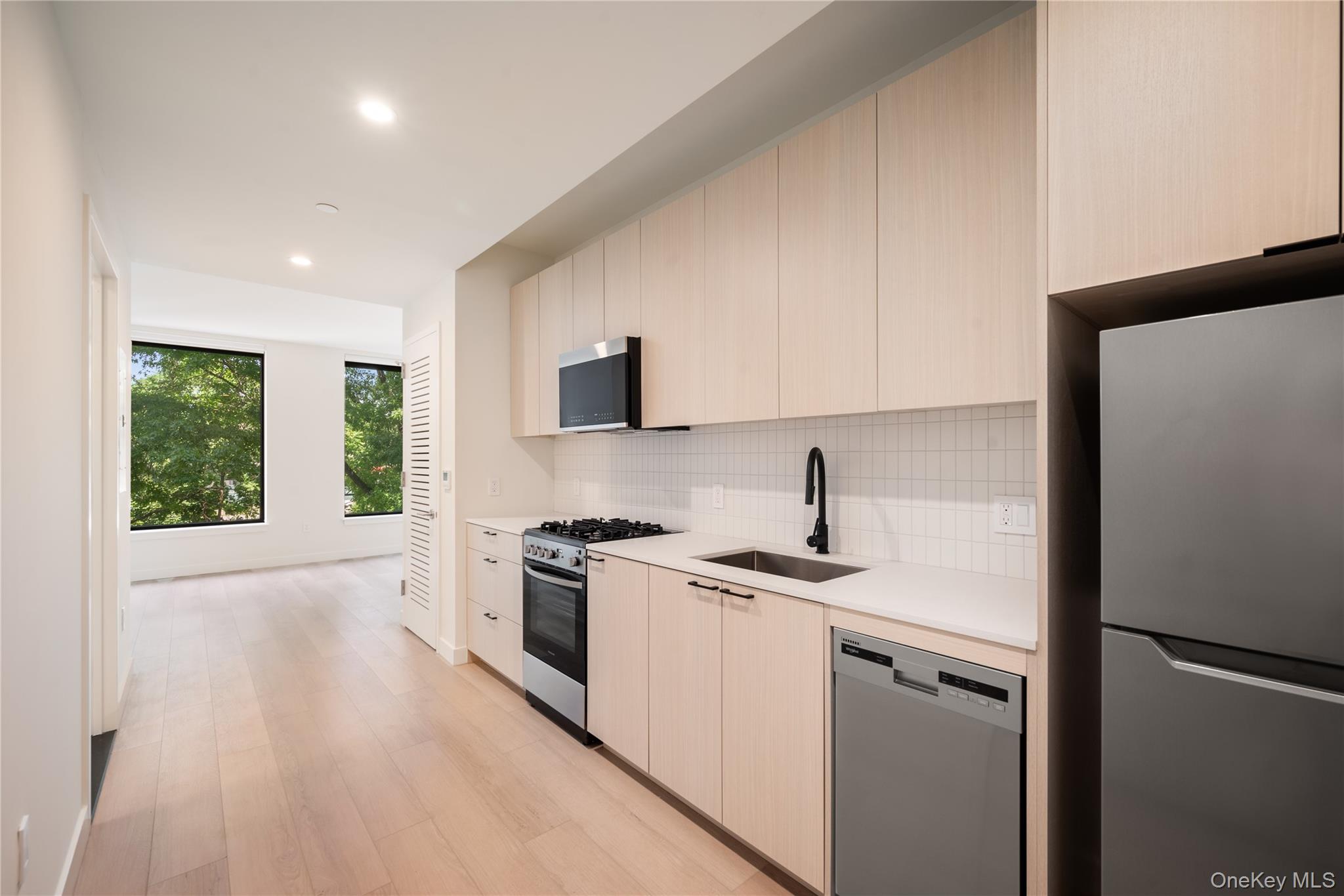 15310-unit #804 15310-unit Avenue Queens, NY 11432 - Photo 6 of 19 a kitchen with a stove a sink and a microwave