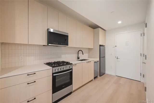 a kitchen with a sink a stove a refrigerator and cabinets