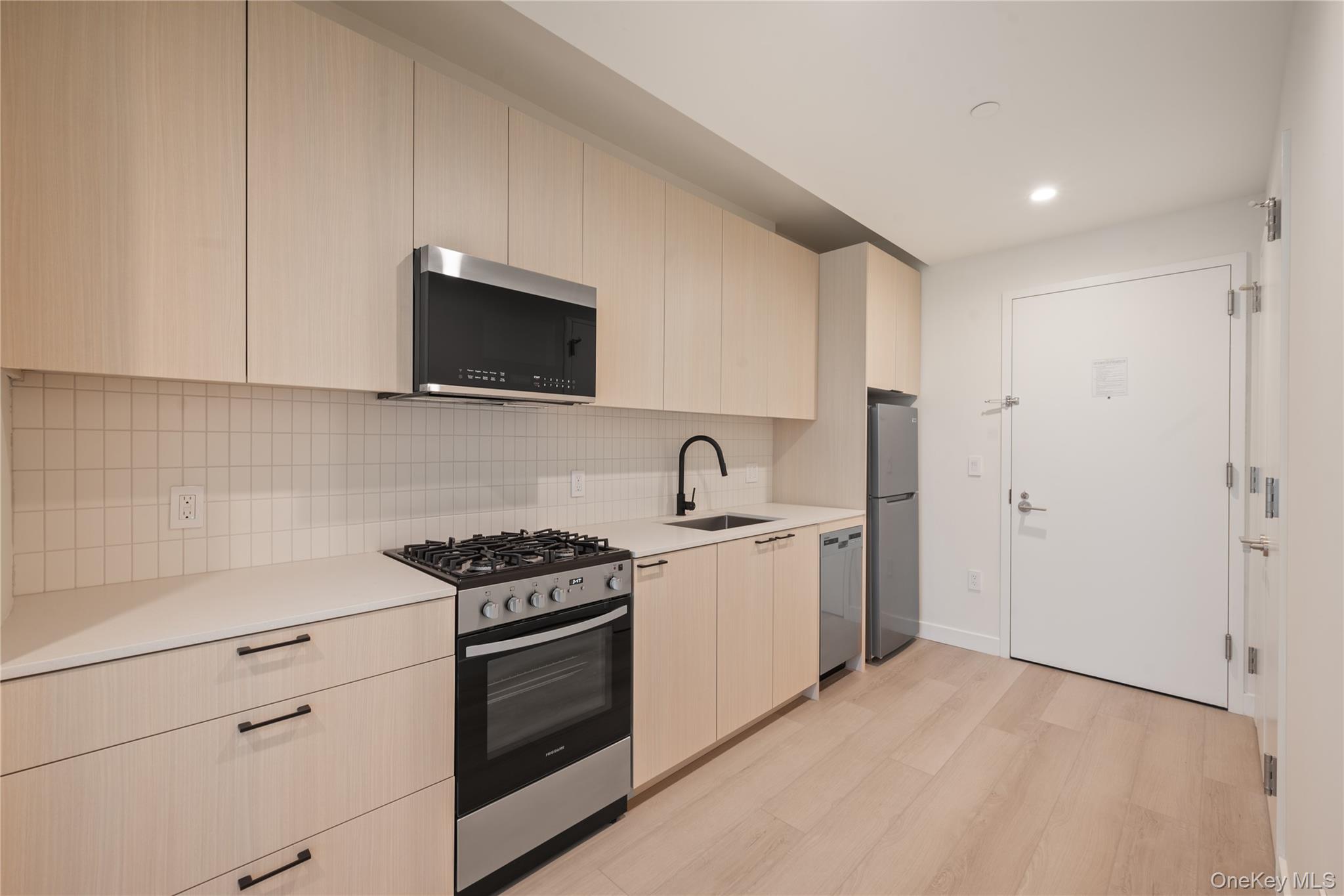 15310-unit #804 15310-unit Avenue Queens, NY 11432 - Photo 7 of 19 a kitchen with stainless steel appliances granite countertop white cabinets and a stove top oven