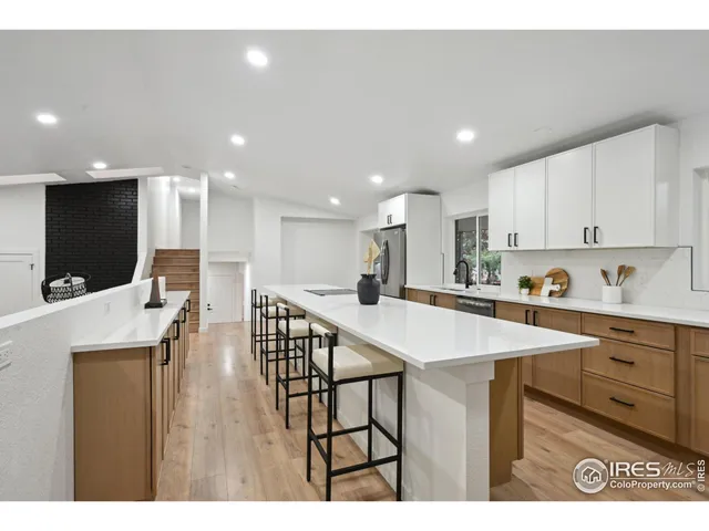 a large kitchen with kitchen island a sink table and chairs