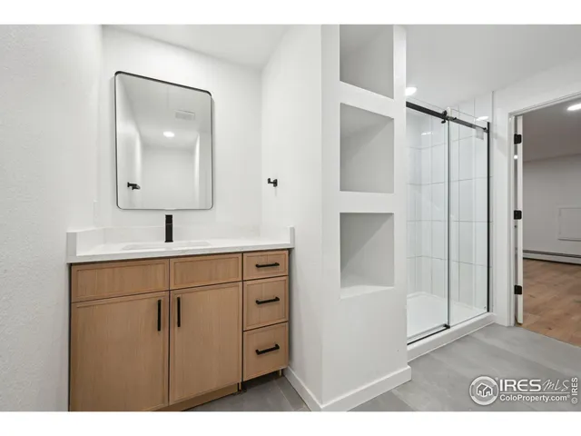 a bathroom with a shower sink and mirror