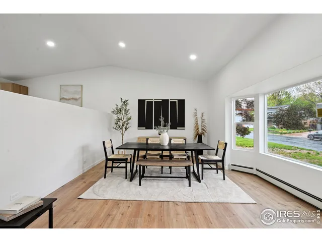 a dining room with furniture a rug and a floor to ceiling window