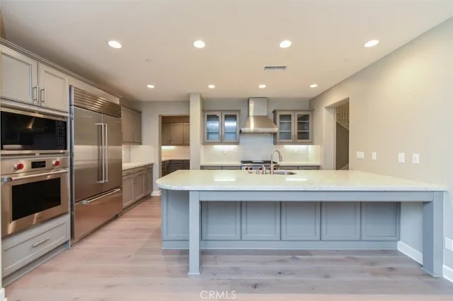 a large kitchen with kitchen island a sink stainless steel appliances and cabinets