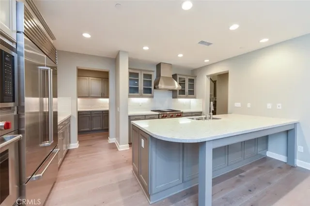a large kitchen with kitchen island a sink stainless steel appliances and cabinets