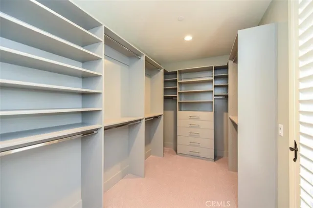 a view of walk in closet with empty racks