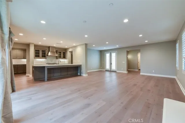 a view of large kitchen with kitchen island a sink dishwasher stove and wooden floors